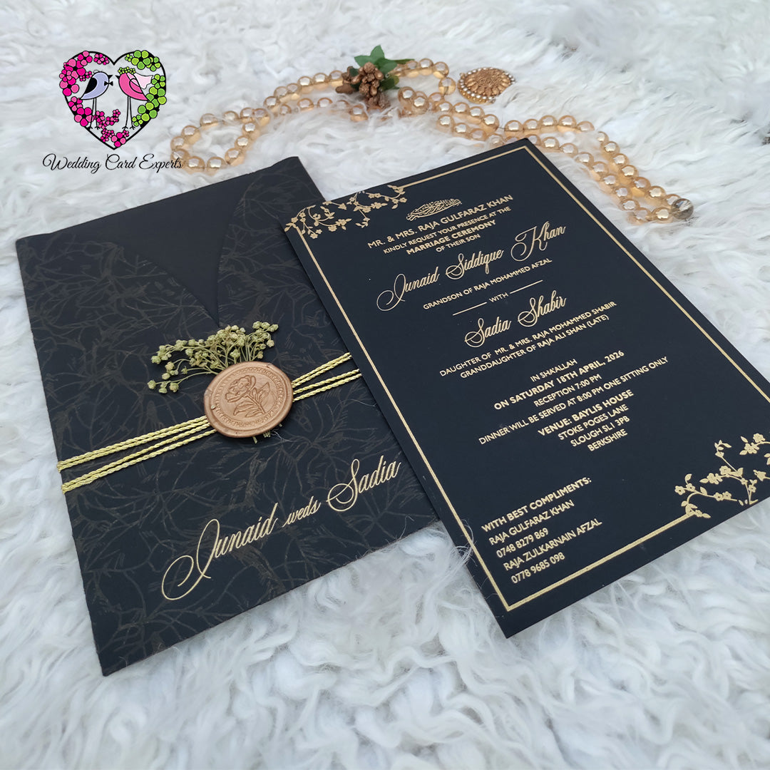 Pakistani wedding card design — matte black V-flap folder with tone-on-tone botanical leaf print, double gold twine, copper rose wax seal and dried baby's breath, wedding card design Pakistan