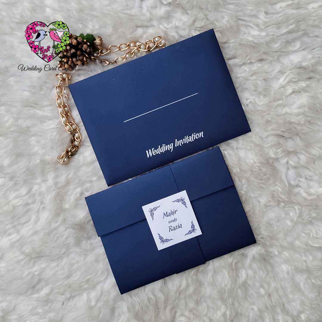 Navy blue pocket fold wedding invitation set, white wedding invitation script cover, couple name tag belly band, Pakistani wedding cards, Wedding Card Experts
