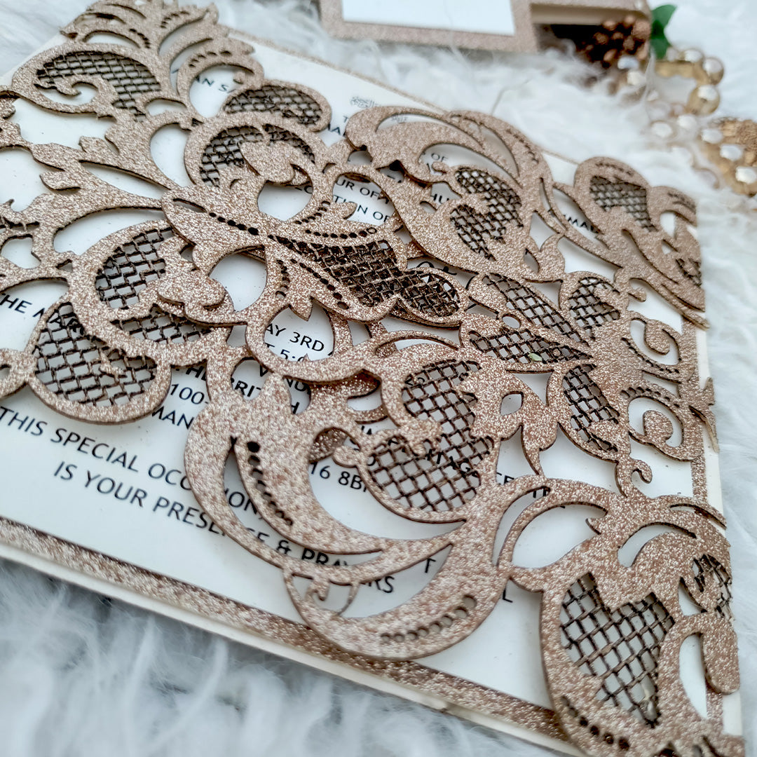 Close-up of glitter gold laser cut floral pattern on Pakistani wedding invitation