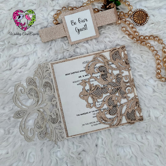 Glitter gold wedding invitation flat lay with pearl jewelry and Be Our Guest belly band