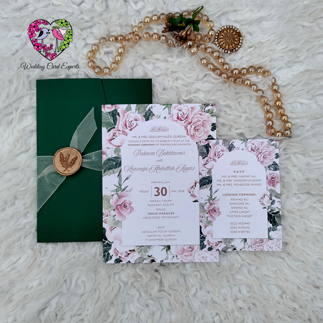 Wedding invitation cards Pakistan —  green folder with organza ribbon beside full-bleed blush rose floral main card and matching programme card with white arch panel, shadi card pakistan floral design