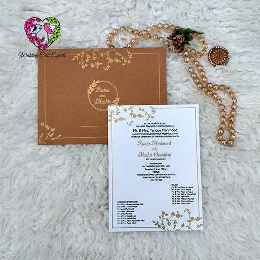 Pakistani wedding card — kraft brown gold printed botanical folder with circular wreath beside premium pearl finish white insert card with gold border, Wedding Card Experts DHA Lahore